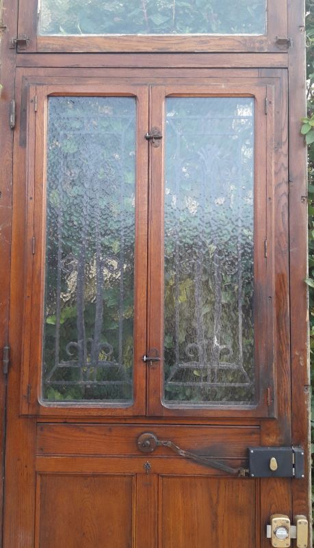 Oak entrance door and its frame and transom, wrought iron gates