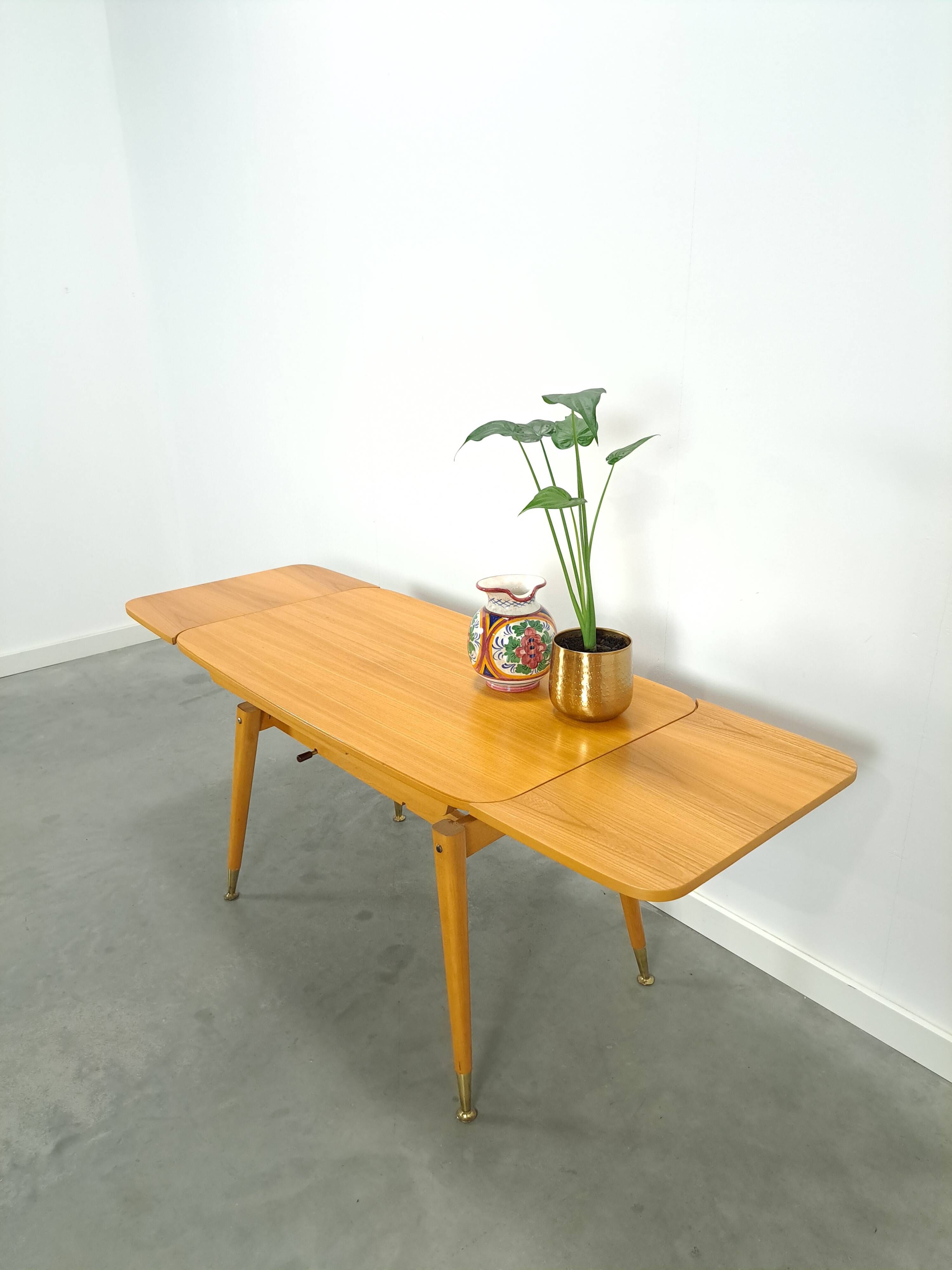 Vintage veneer table with pretty angular legs and brass at the base of the legs.