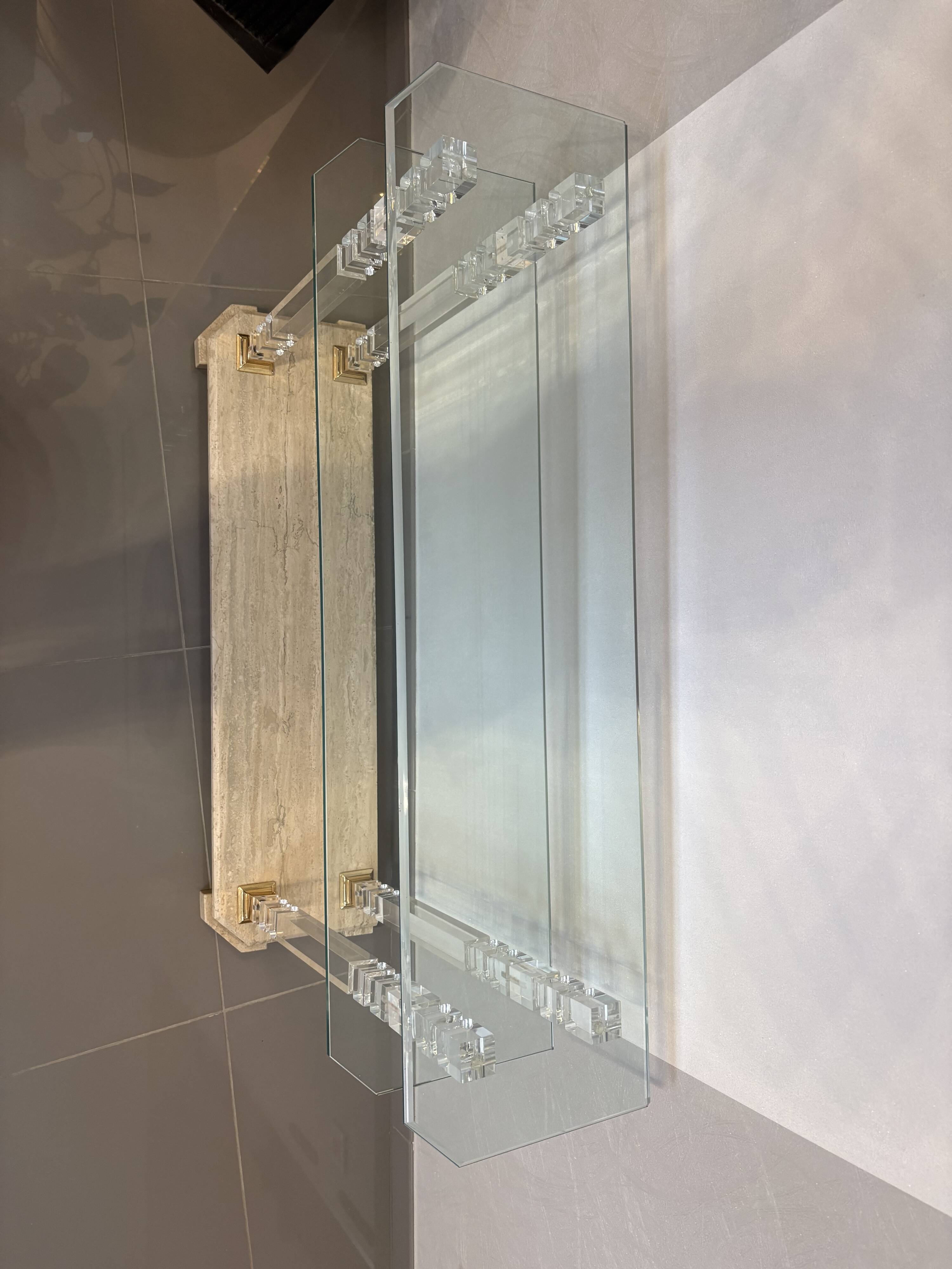 Hollywood Regency console style in travertine, glass, and Lucite.