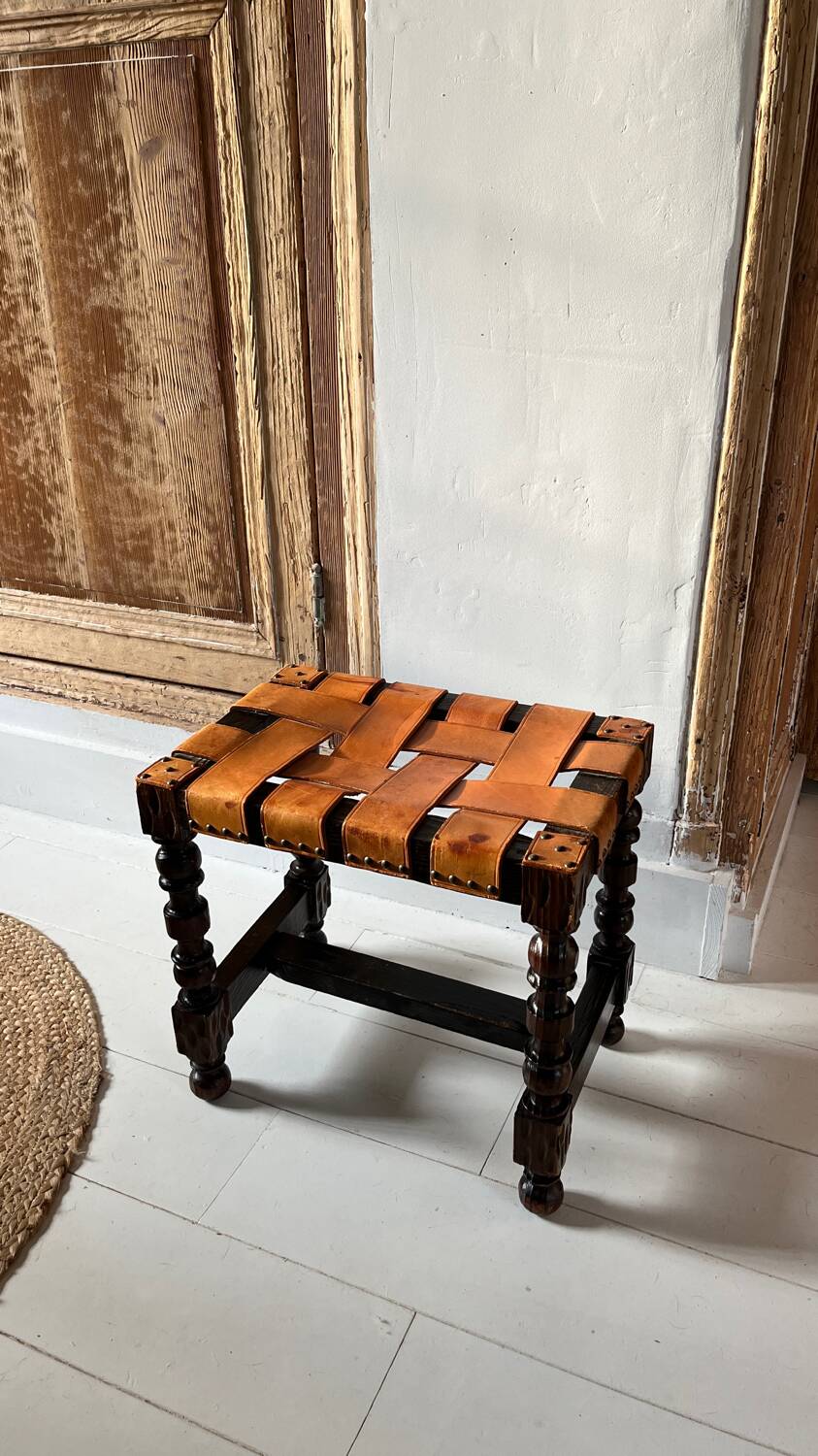 Antique turned wooden stool with woven leather.