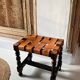 Antique turned wooden stool with woven leather.