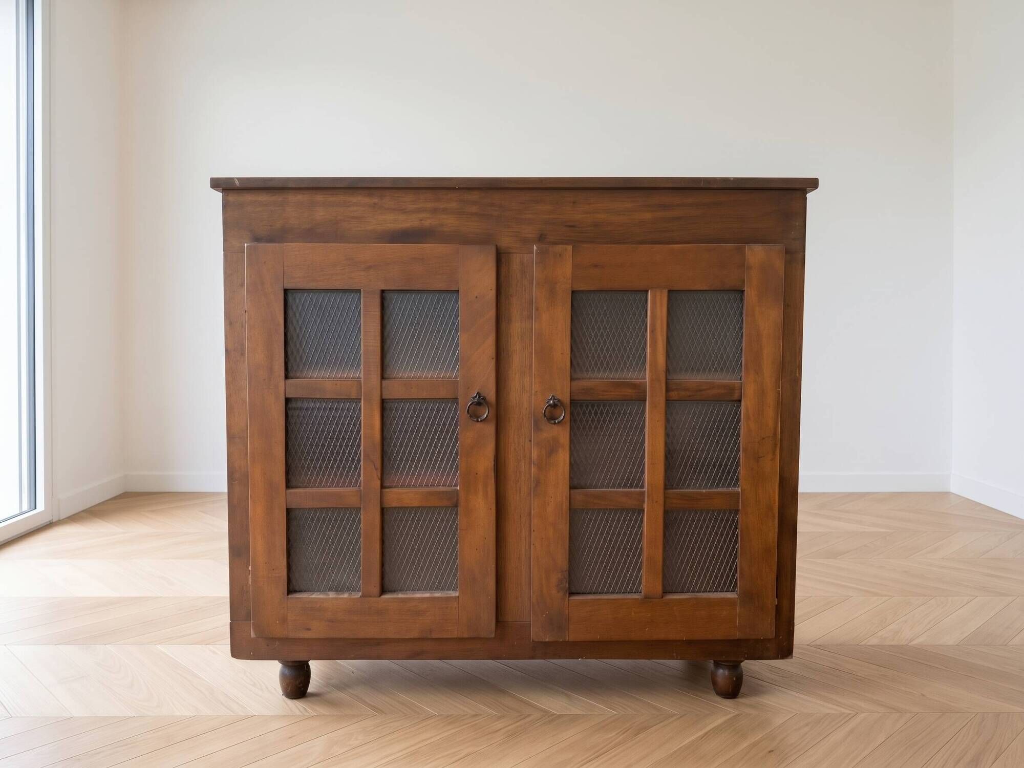Small antique wooden sideboard with glass doors.