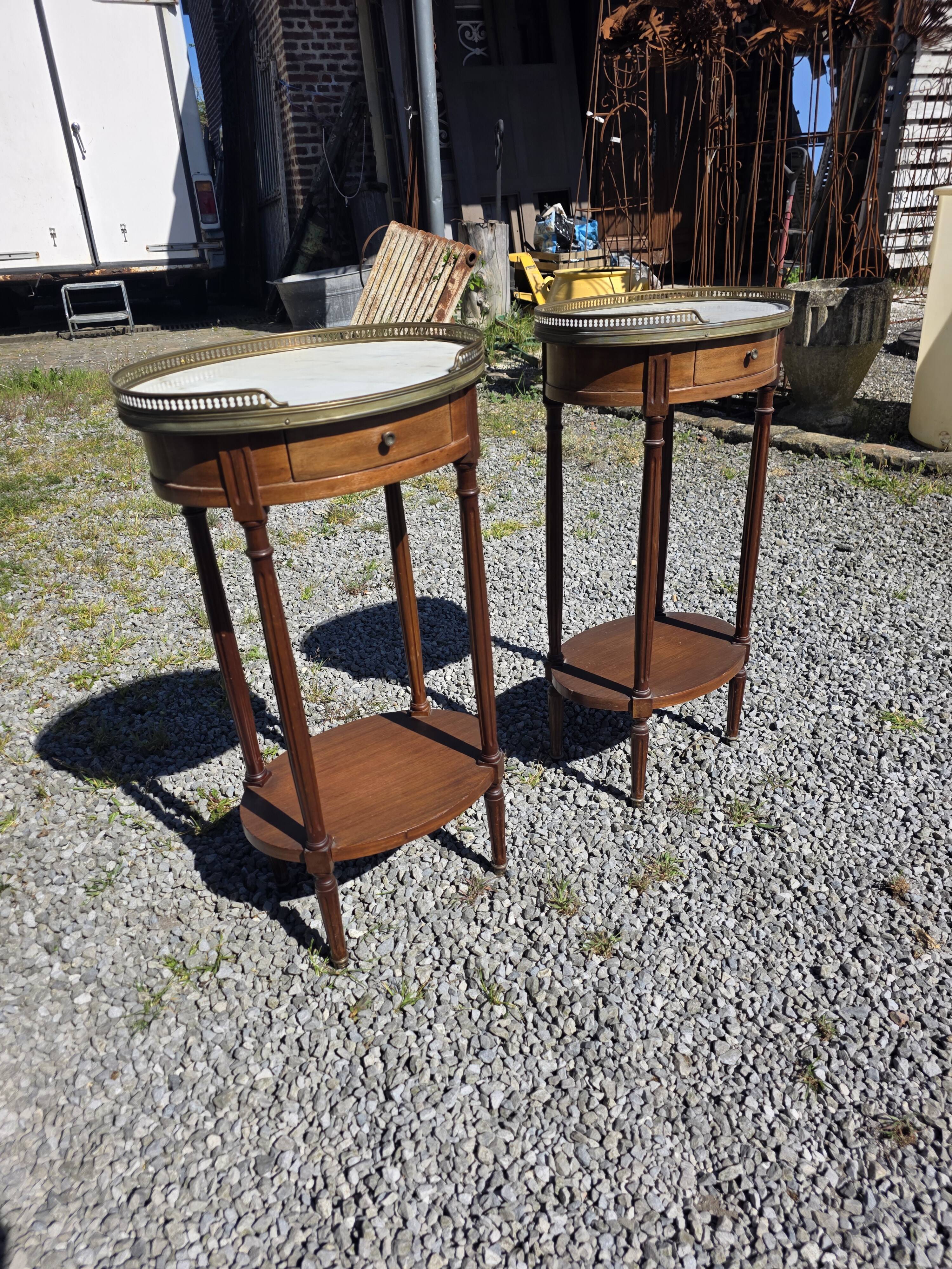 Pair of Louis XVI style bedside tables in mahogany, with marble tops.