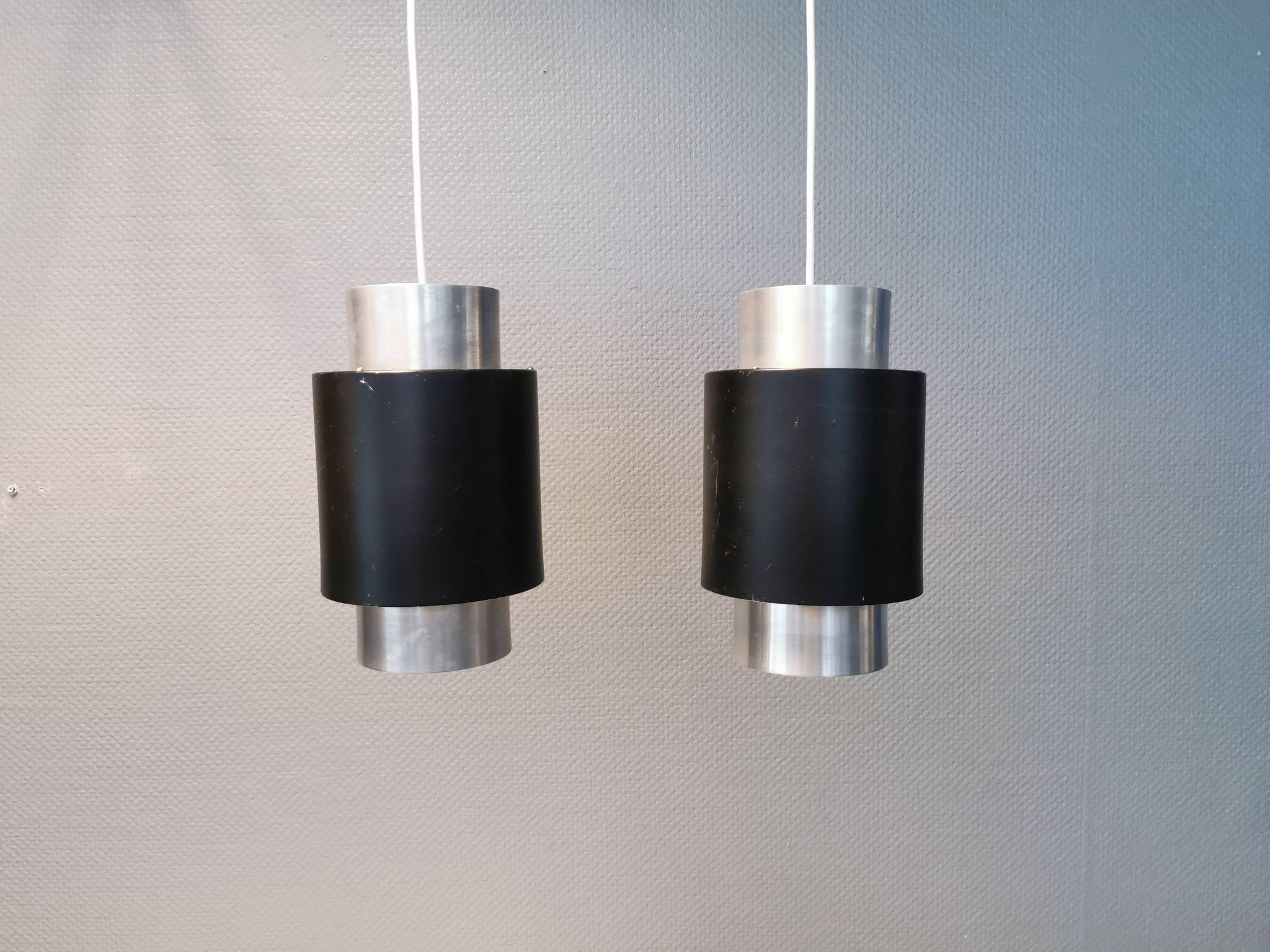 A set of beautiful cylinder shaped hanging lamps in silver color with black "ring" Danish 1970s.