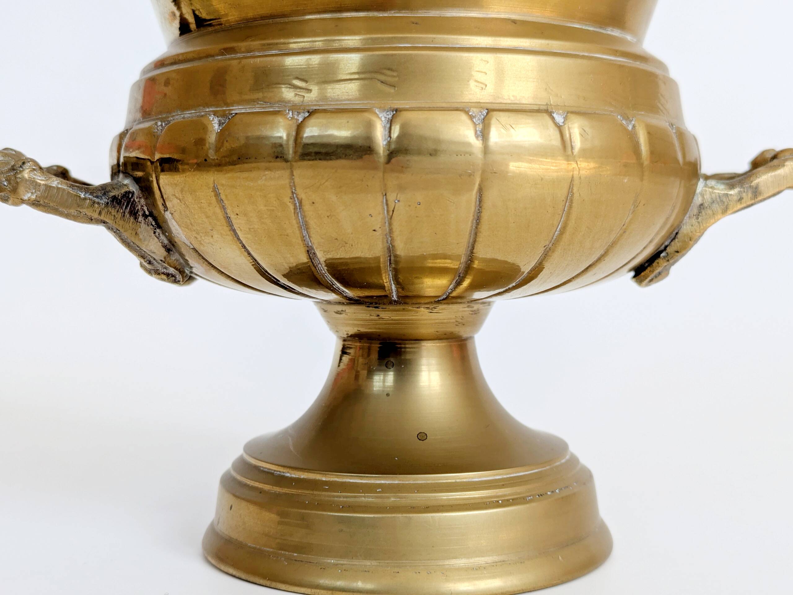 Vintage brass cache-pot on a stand with handles, classic decor.