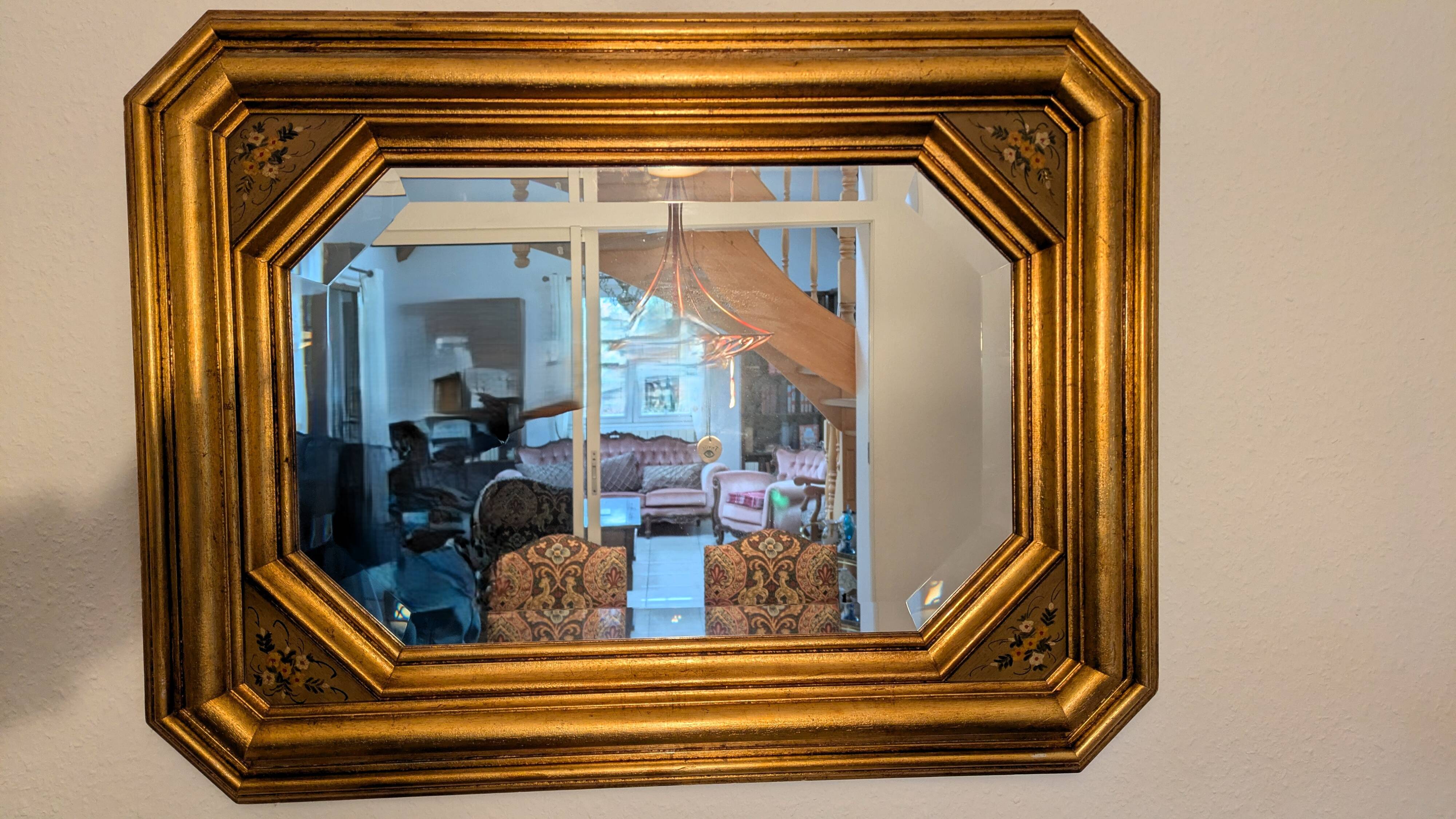 Antique octagonal mirror in gilded wood with painted floral decoration.