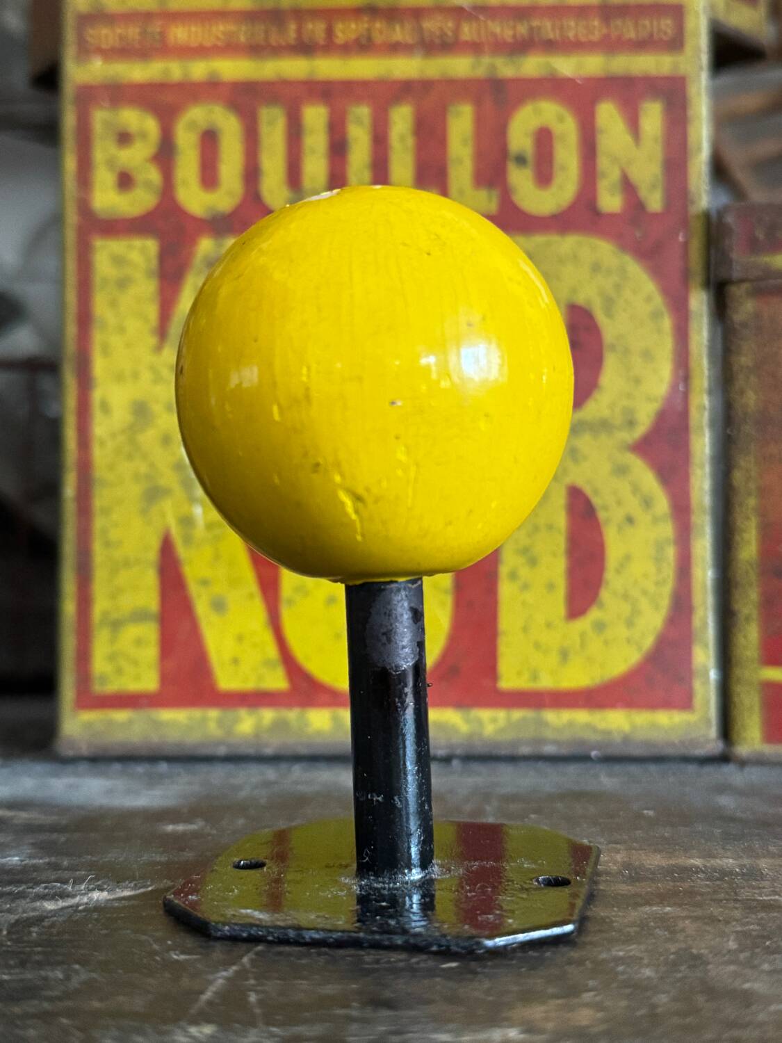 Vintage yellow wooden wall-mounted ball coat hook.