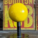 Vintage yellow wooden wall-mounted ball coat hook.