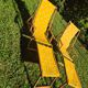 2 vintage Chilean deck chairs made of wood and yellow fabric printed with sailboats, with footrests.