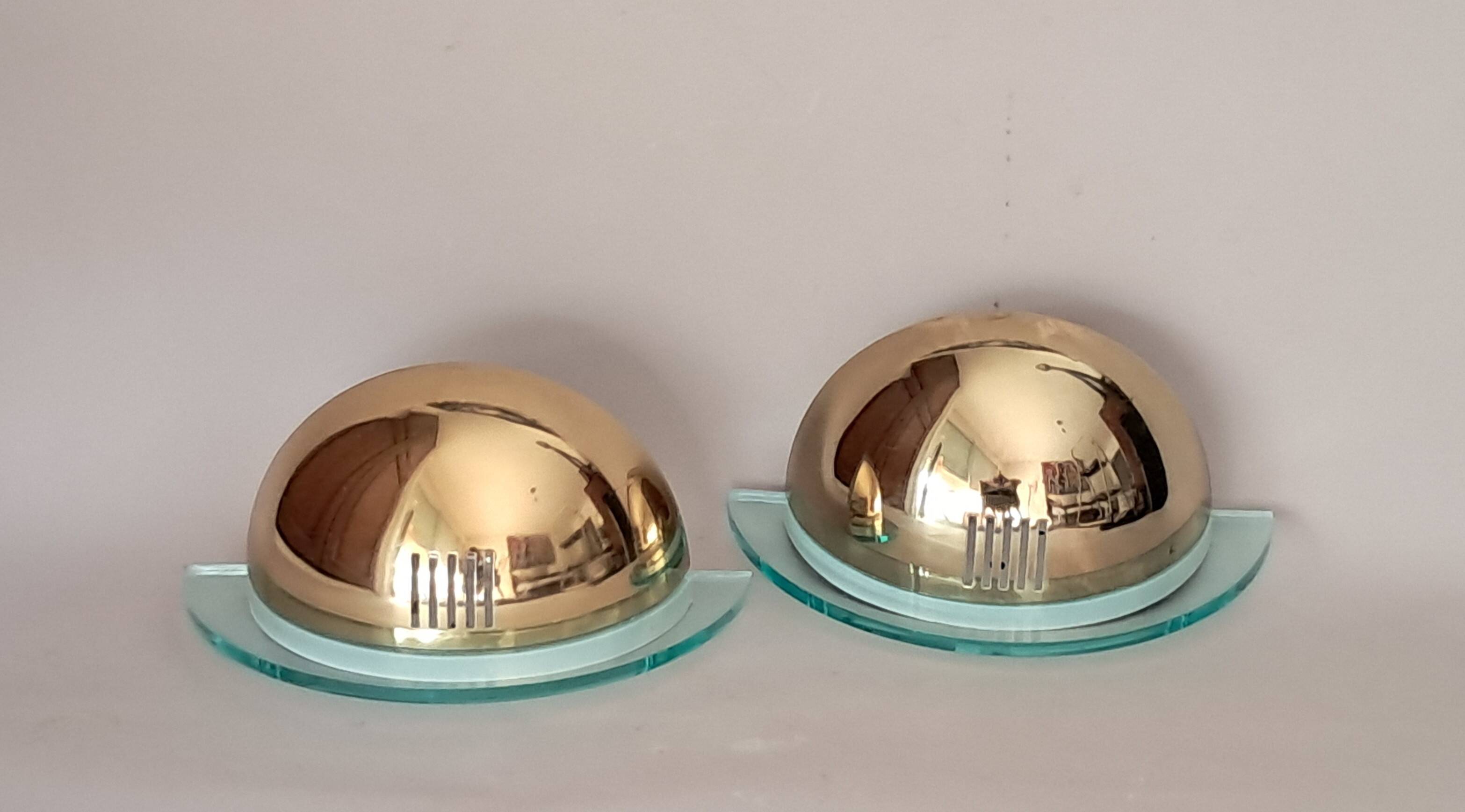 Pair of gold metal and plexiglass wall lights, circa 1980.