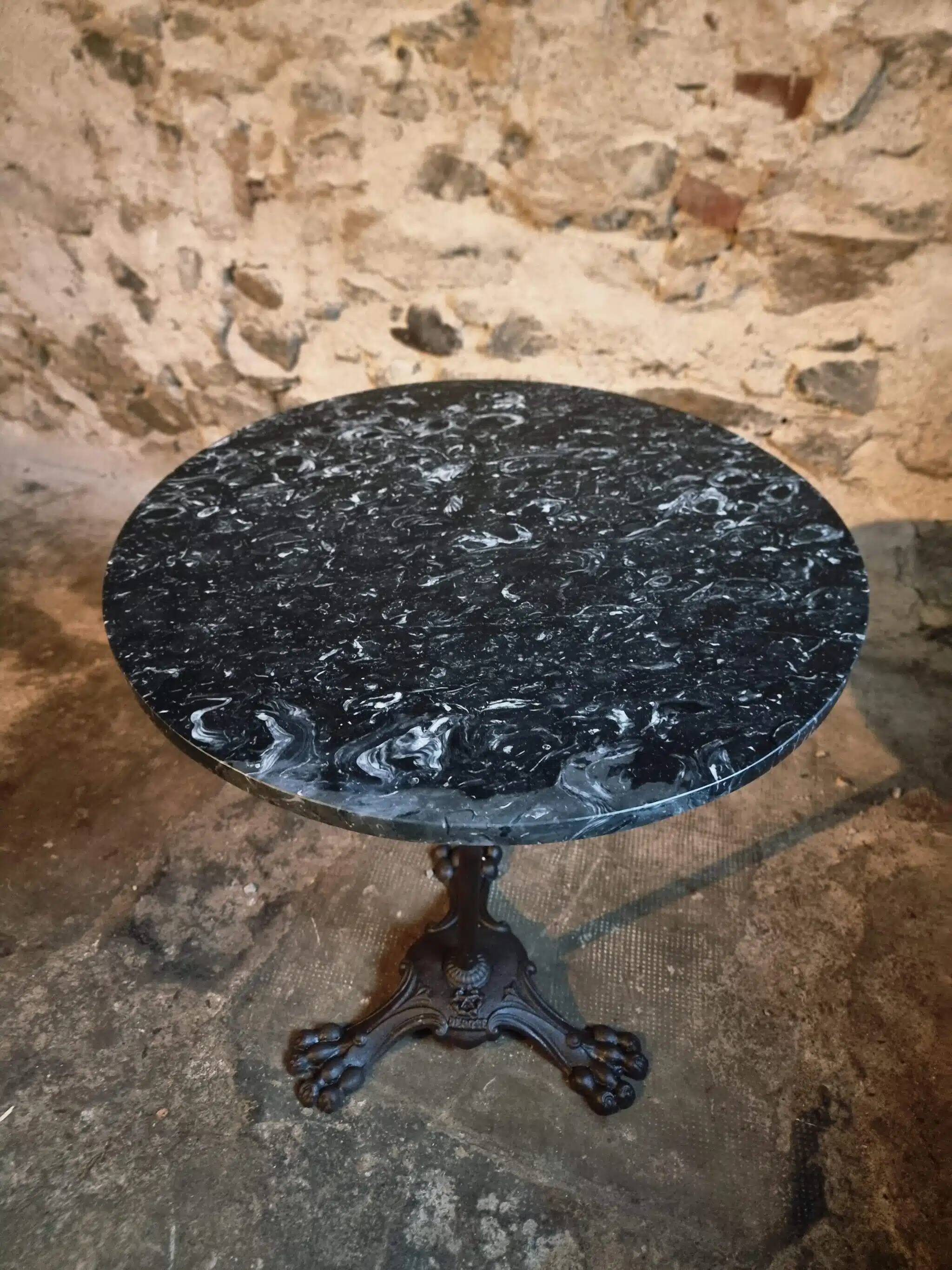 Old French bistro table with a marble top and a cast iron base.