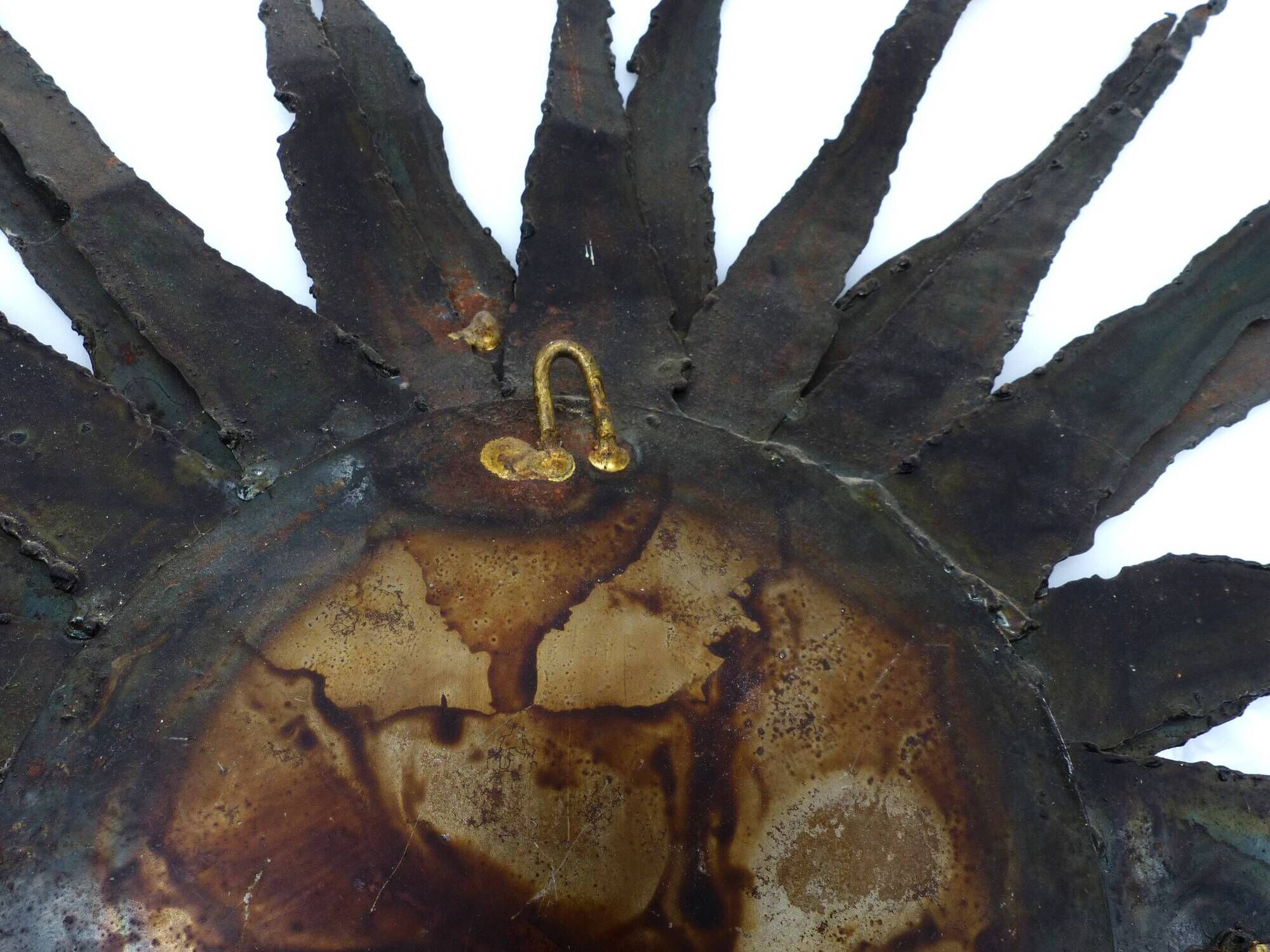 Large brutalist sun mirror in patinated metal with gold accents, 1970.