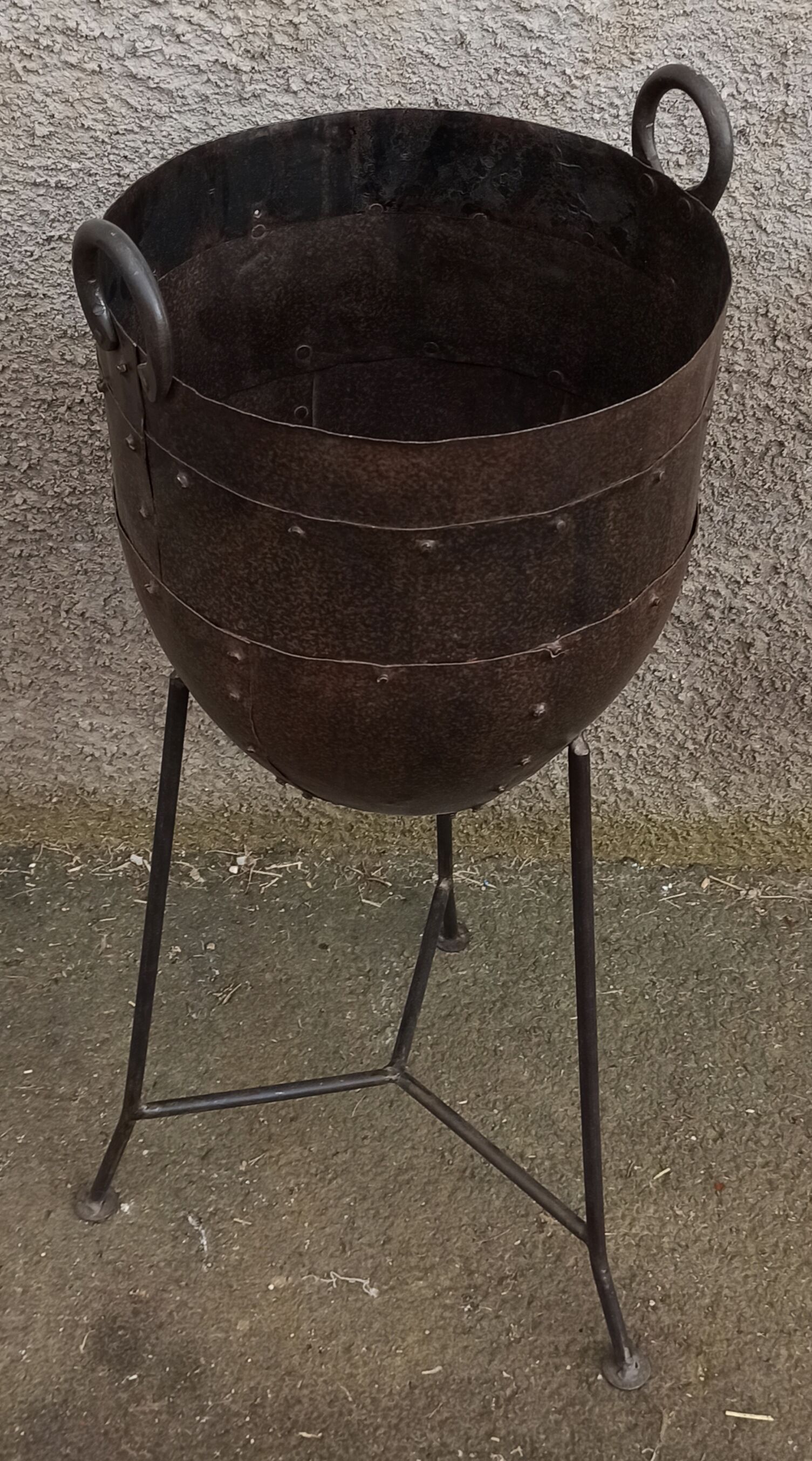 Old metal pot on foot