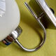 Pair of chrome metal wall lights with white glass globe.