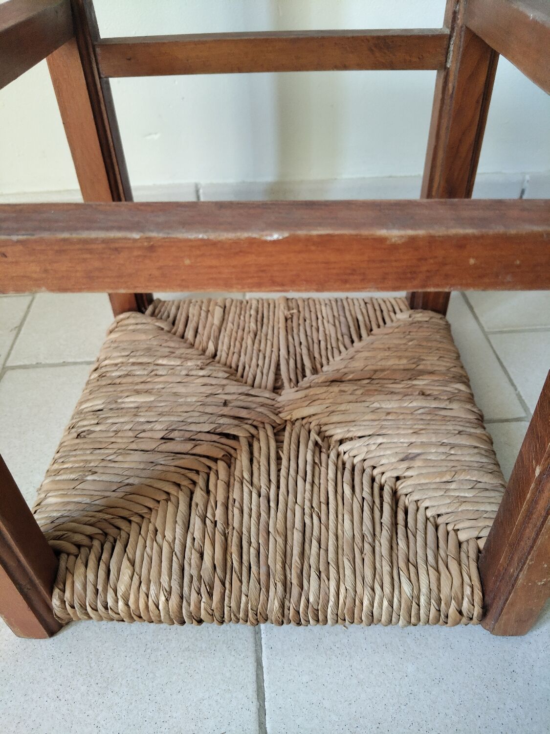 Antique campaign stool in solid wood with a straw seat.