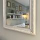 Antique Louis-Philippe mirror with pearls and shells, white patina.