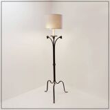 Wrought iron tripod floor lamp decorated with stylized animal heads