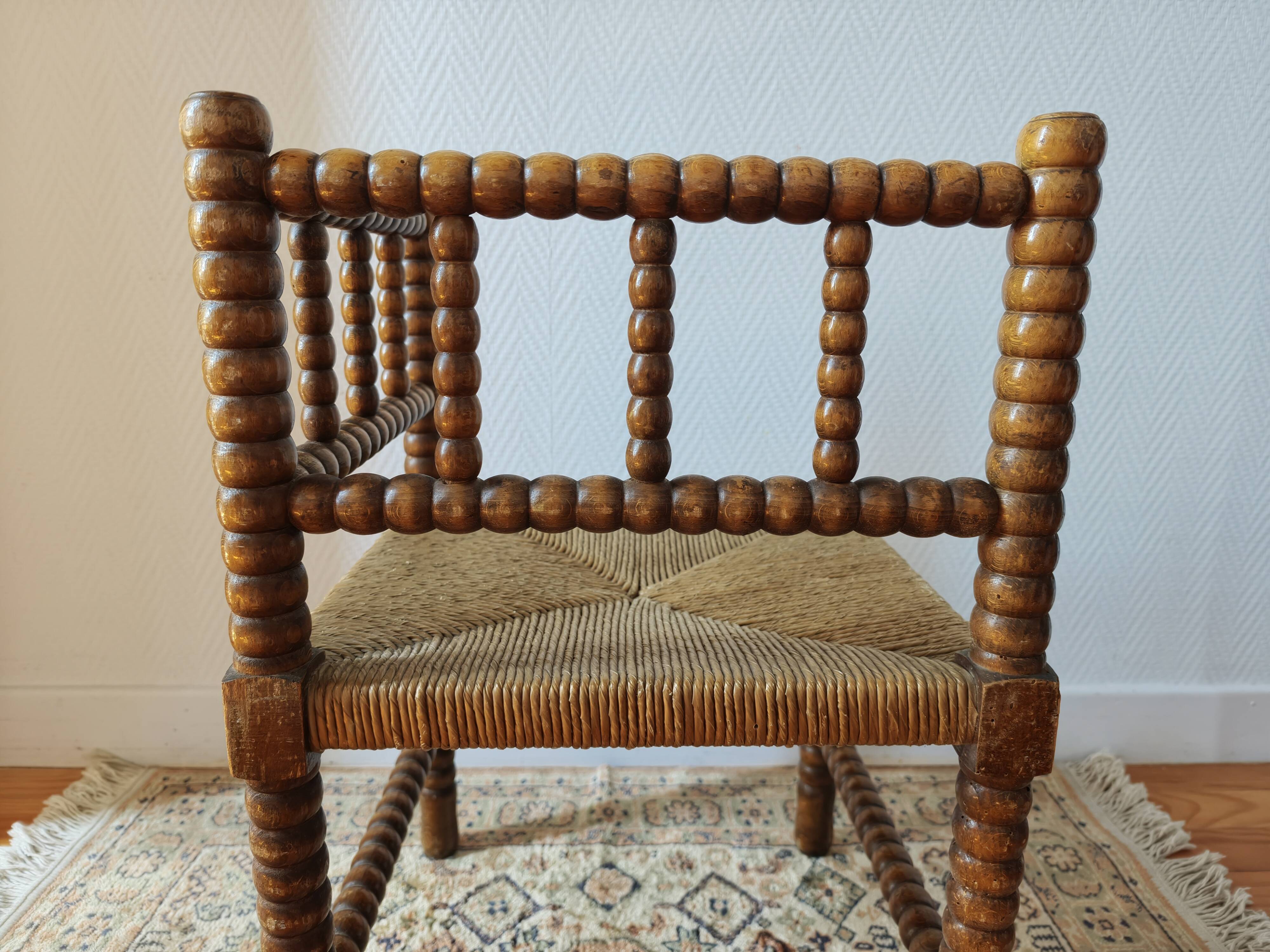 Antique corner chair by the fire with turned wood and straw seat.