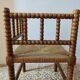 Antique corner chair by the fire with turned wood and straw seat.