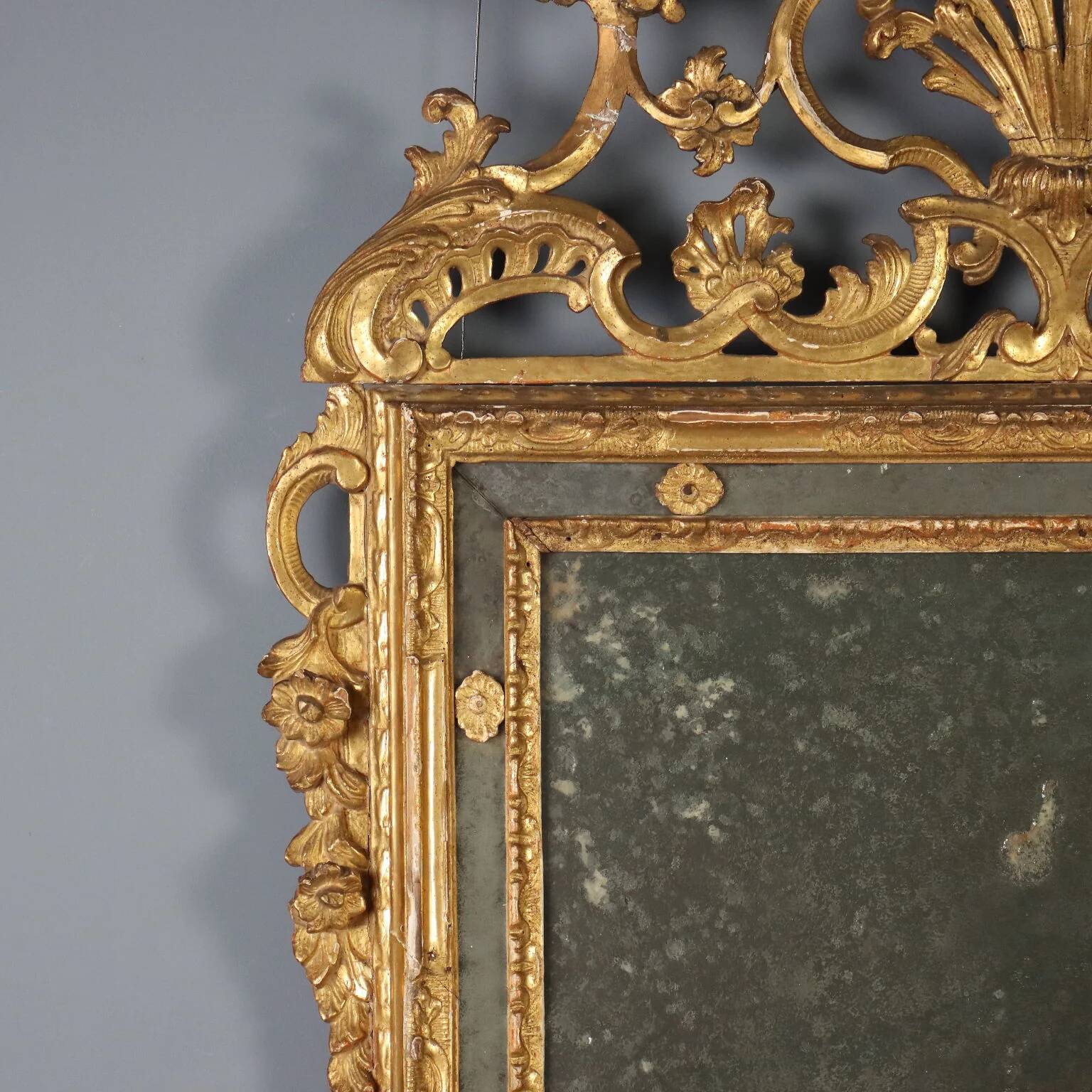 Antique gilded wooden mirror with rococo patterns, Italy, 18th century.