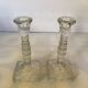Pair of tall candle holders in the shape of a flower with a square base.