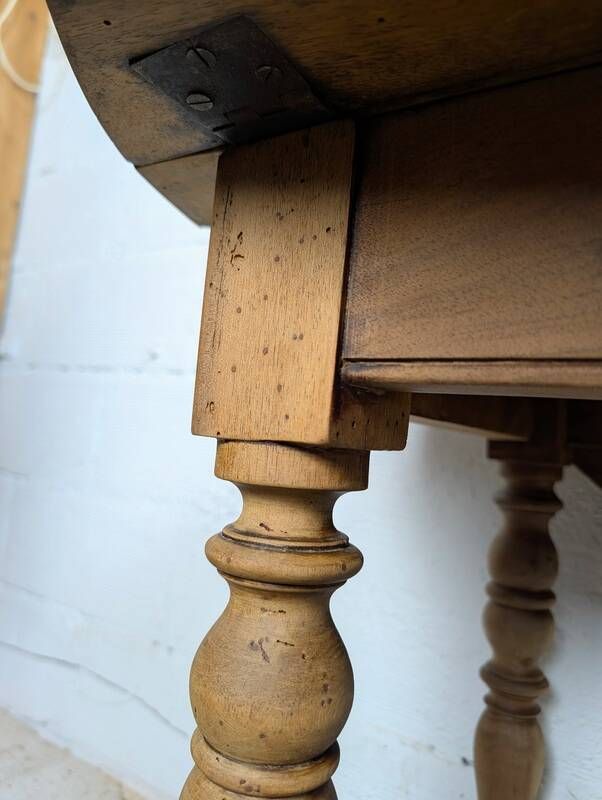 Antique wooden drop-leaf table with turned legs.