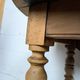 Antique wooden drop-leaf table with turned legs.