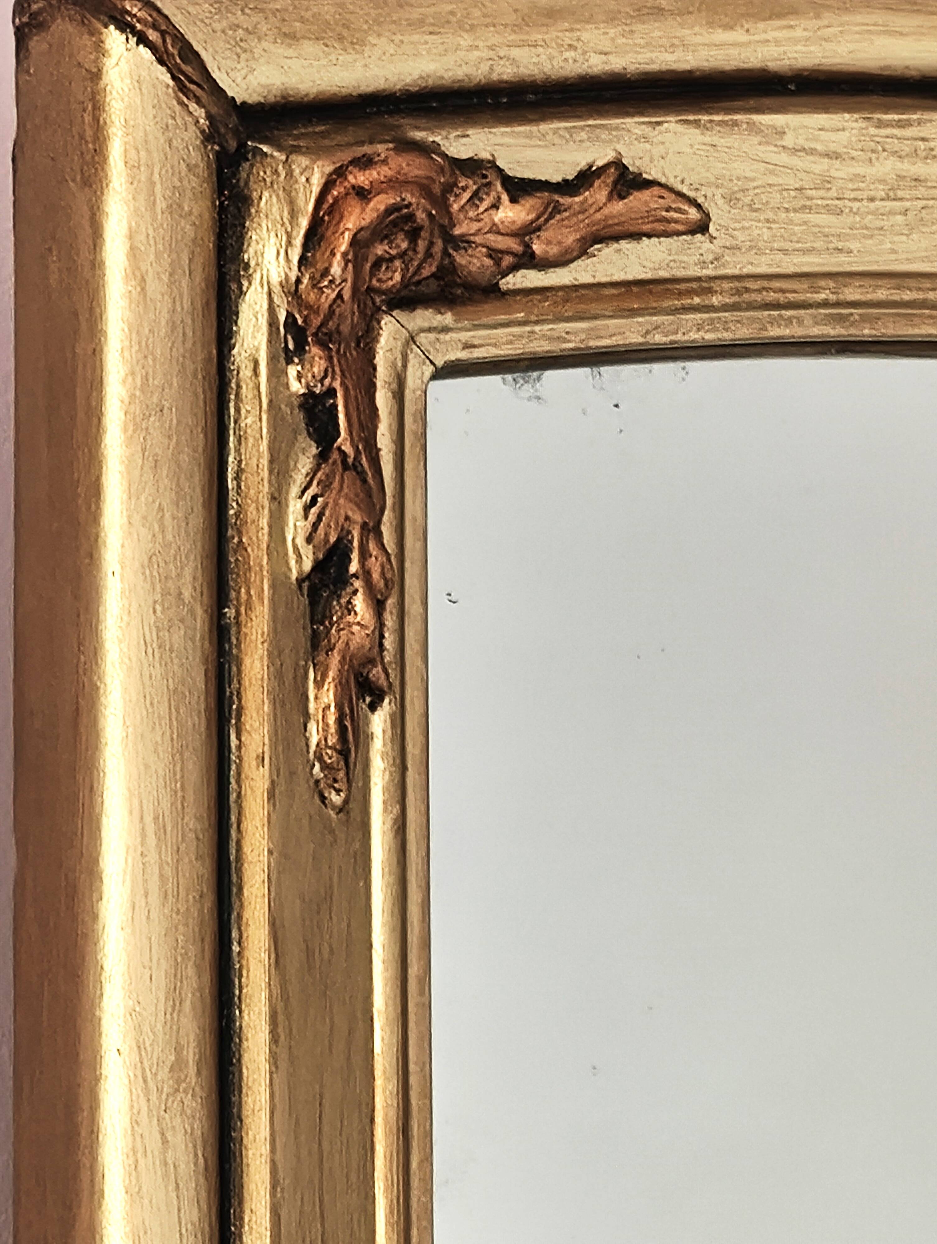 Art Deco mirror in gilded wood with curved floral decorations.