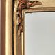 Art Deco mirror in gilded wood with curved floral decorations.