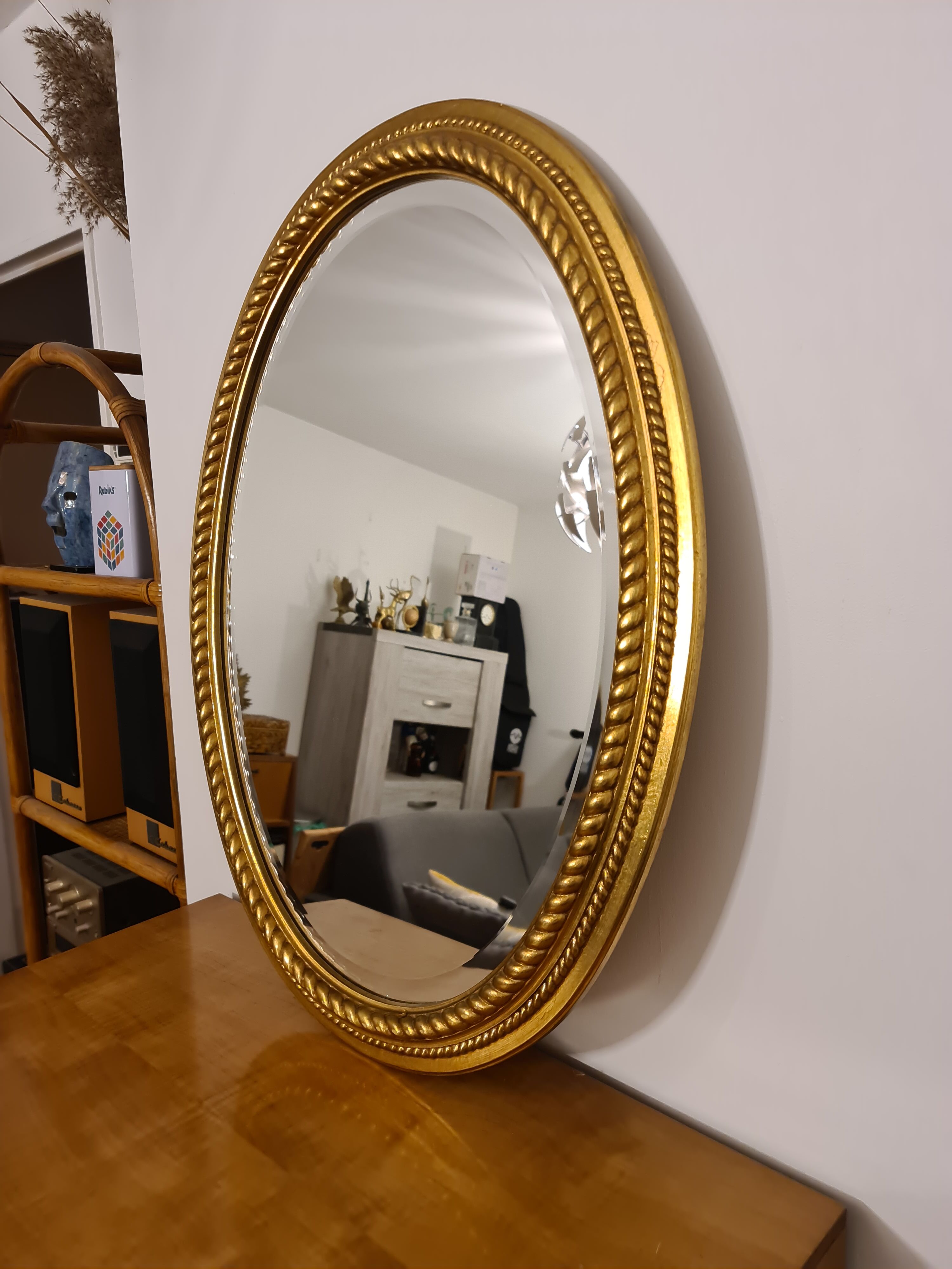 Beveled oval mirror in gilded wood 78×58cm