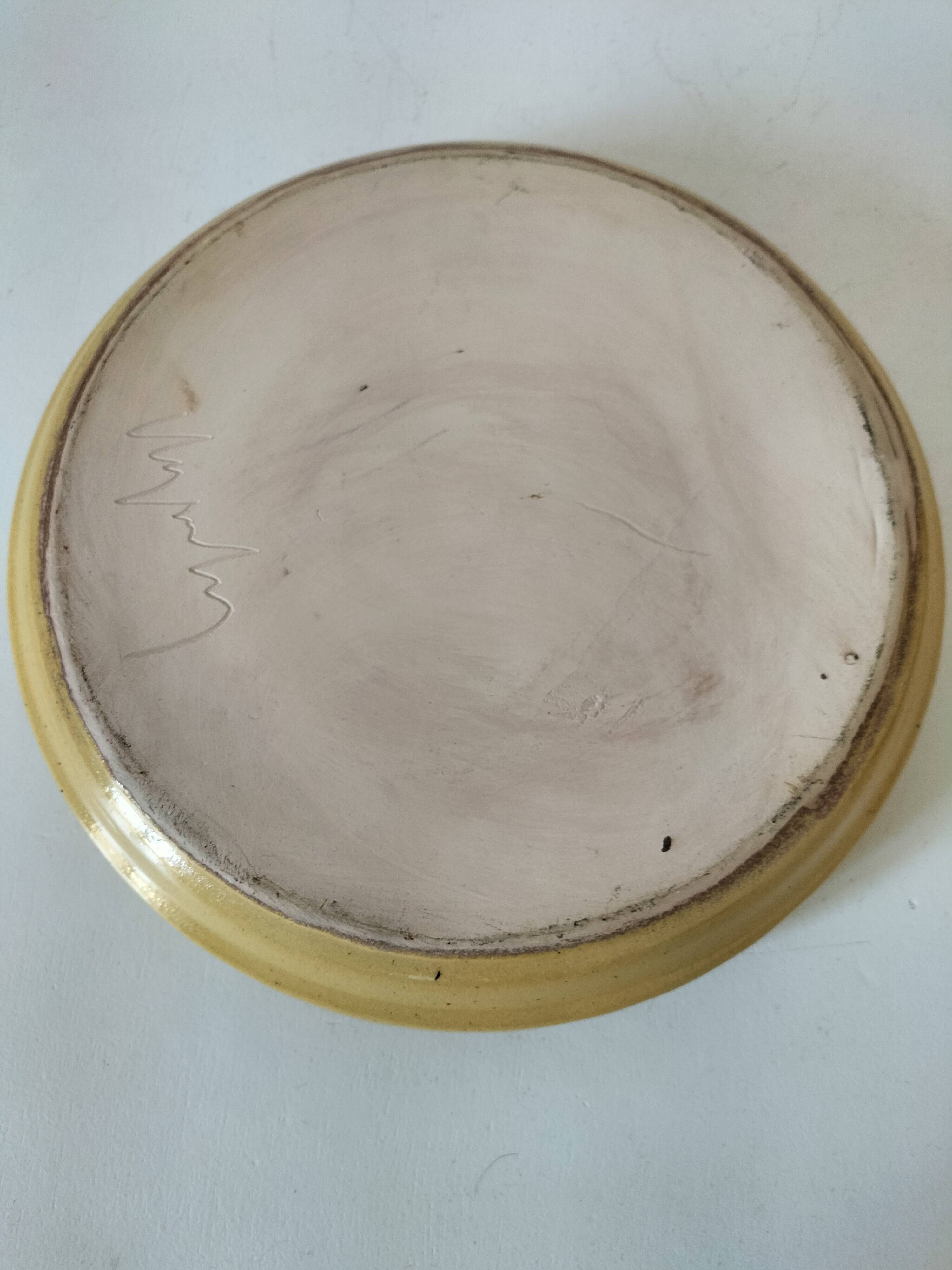 Blue floral glazed stoneware plate with a yellow rim.