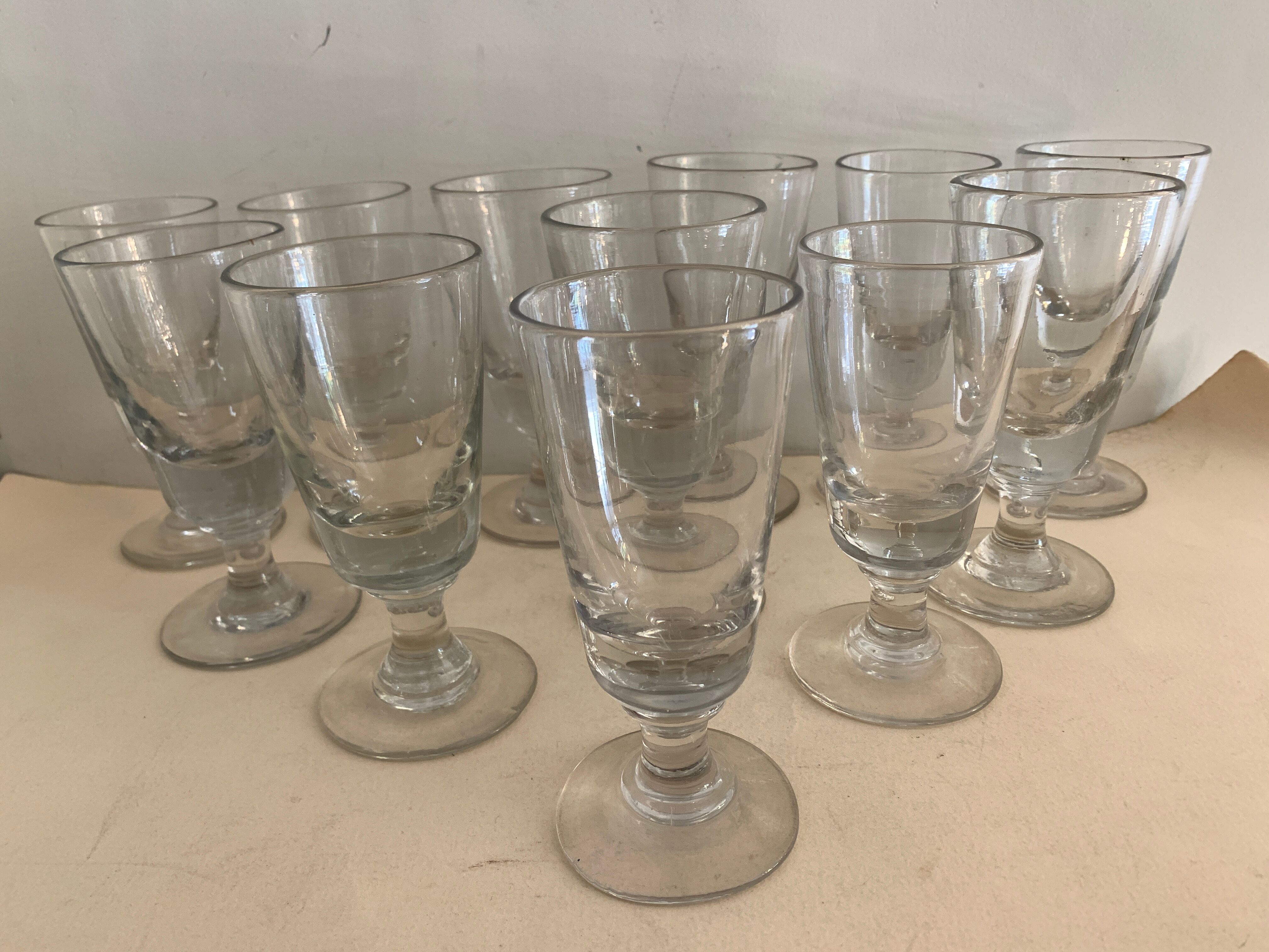 12 old glasses on foot at bistro or absinthe