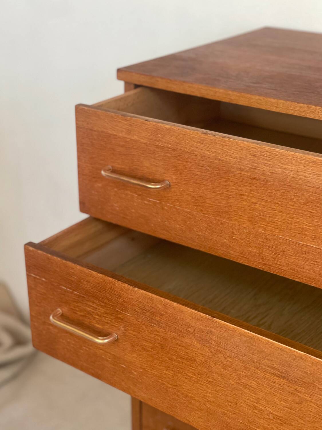 Vintage 1960s chest of drawers with covered handles.