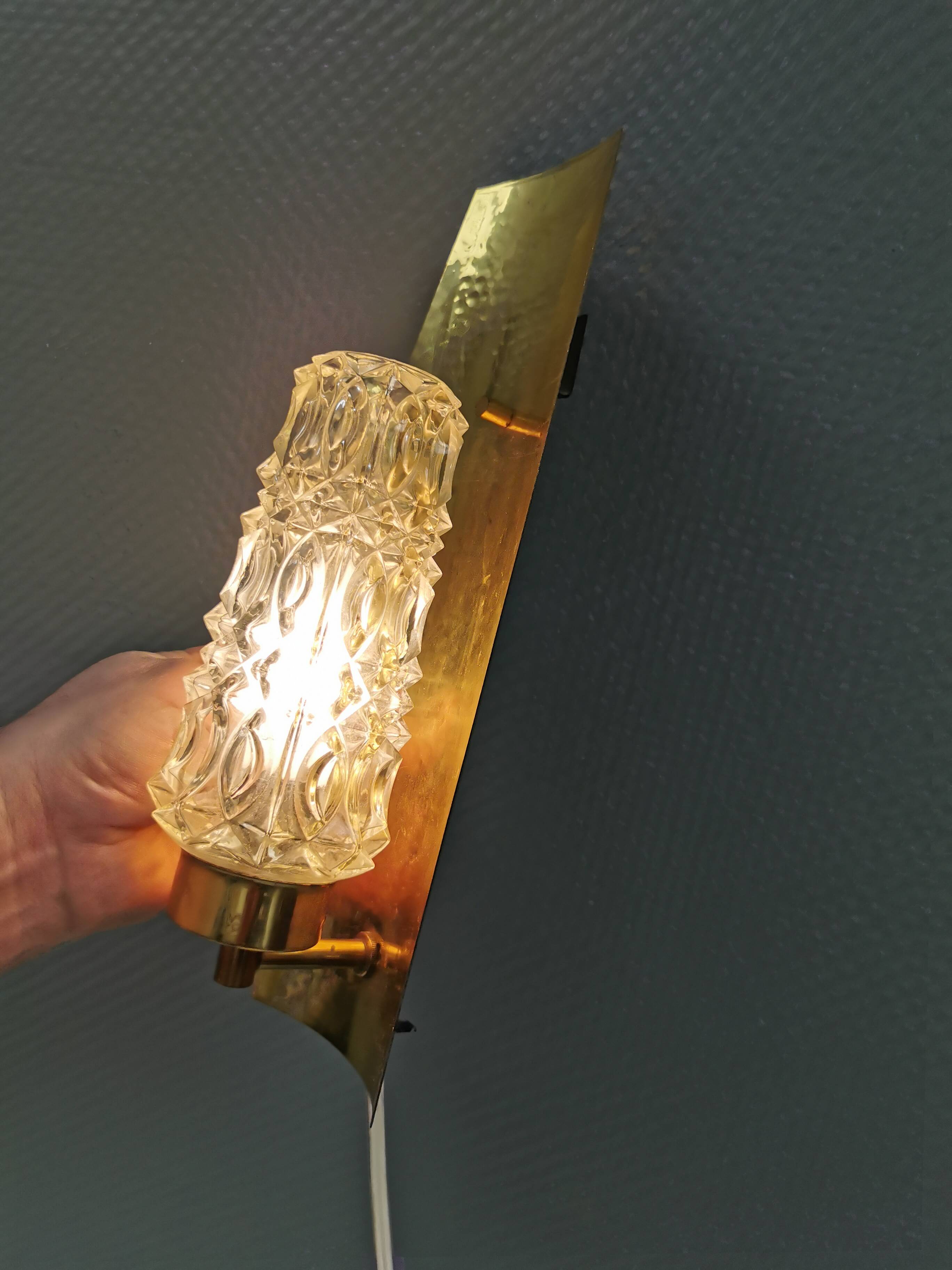 Older wall lamp in brass with hard pressed glass shade.