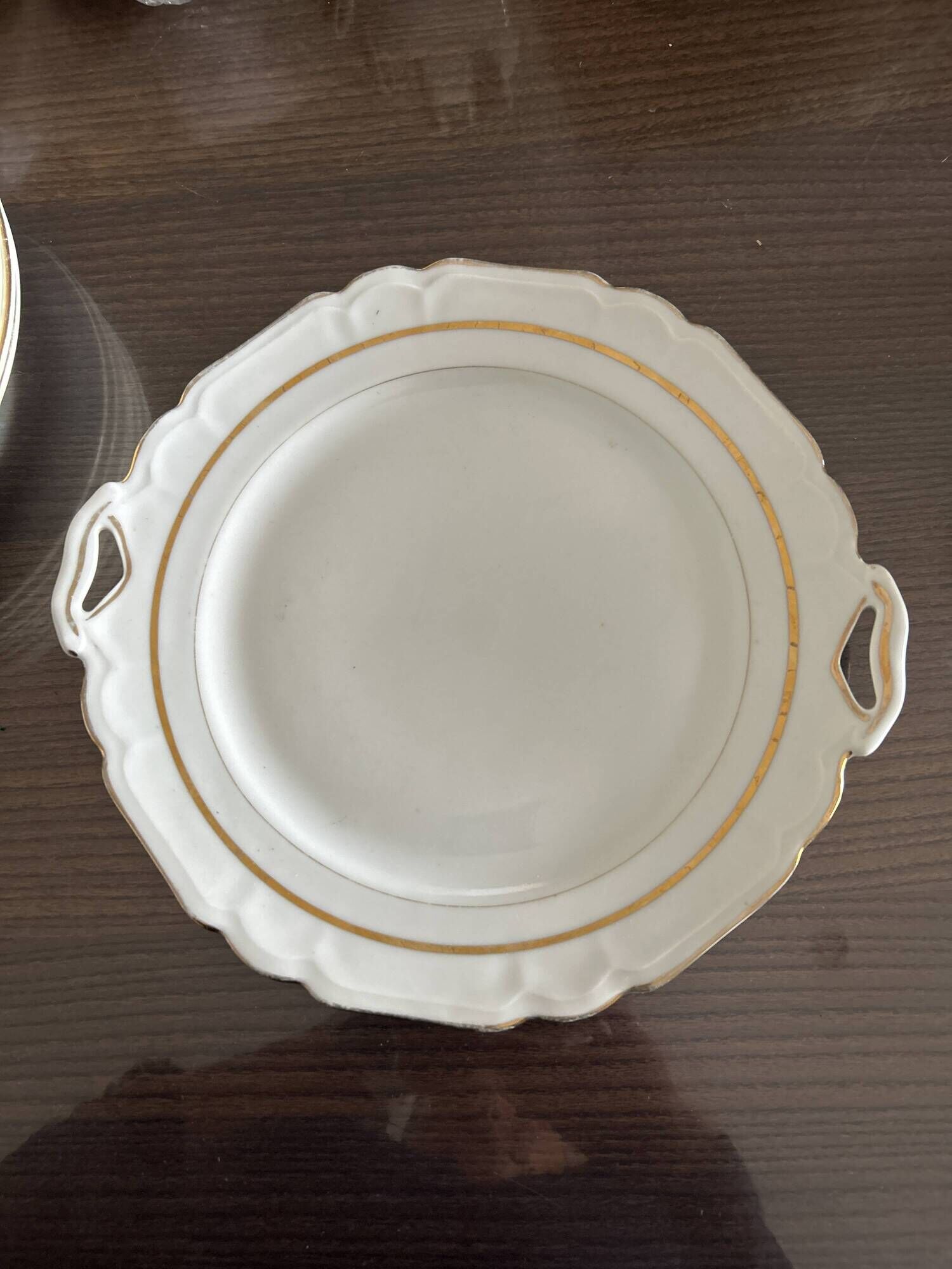 This dish appears to be a serving dish or a round plate with handles made of porcelain.