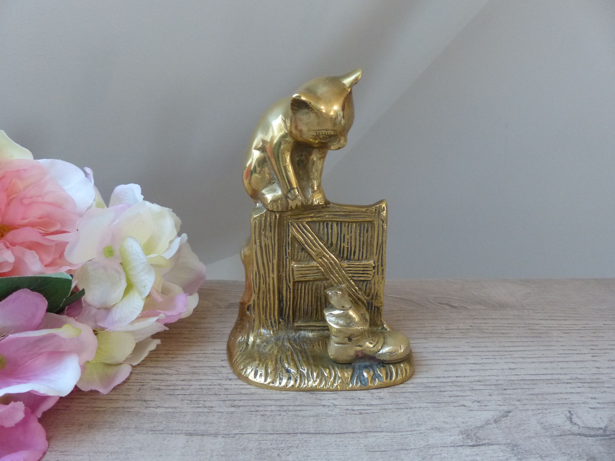 Golden brass cat figurine on fence looking at a mouse in a Vintage India shoe
