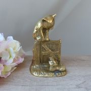 Golden brass cat figurine on fence looking at a mouse in a Vintage India shoe