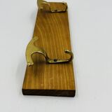Vintage wall coat rack in brass and wood design.