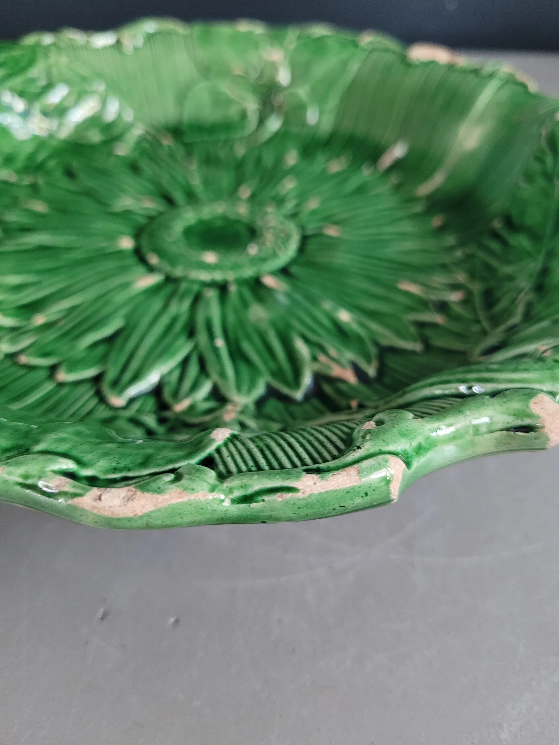 Plate decorated with a sunflower motif in slipware.