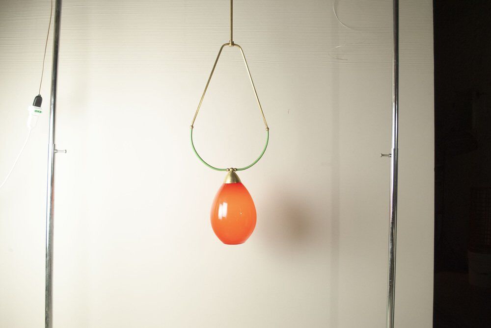 Hanging lamp with a brass frame in the shape of scales and a red-purple Murano glass diffuser.