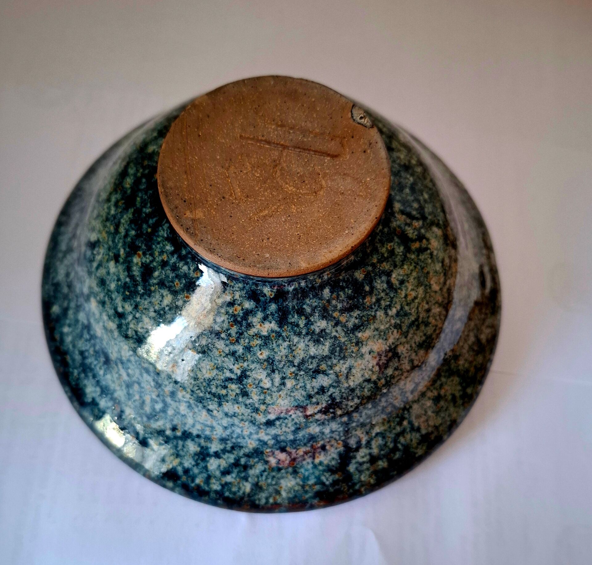 Bowl on a circular base or small blue ceramic dish.