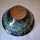 Bowl on a circular base or small blue ceramic dish.