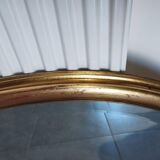 Large and elegant oval gilded mirror with its beveled glass