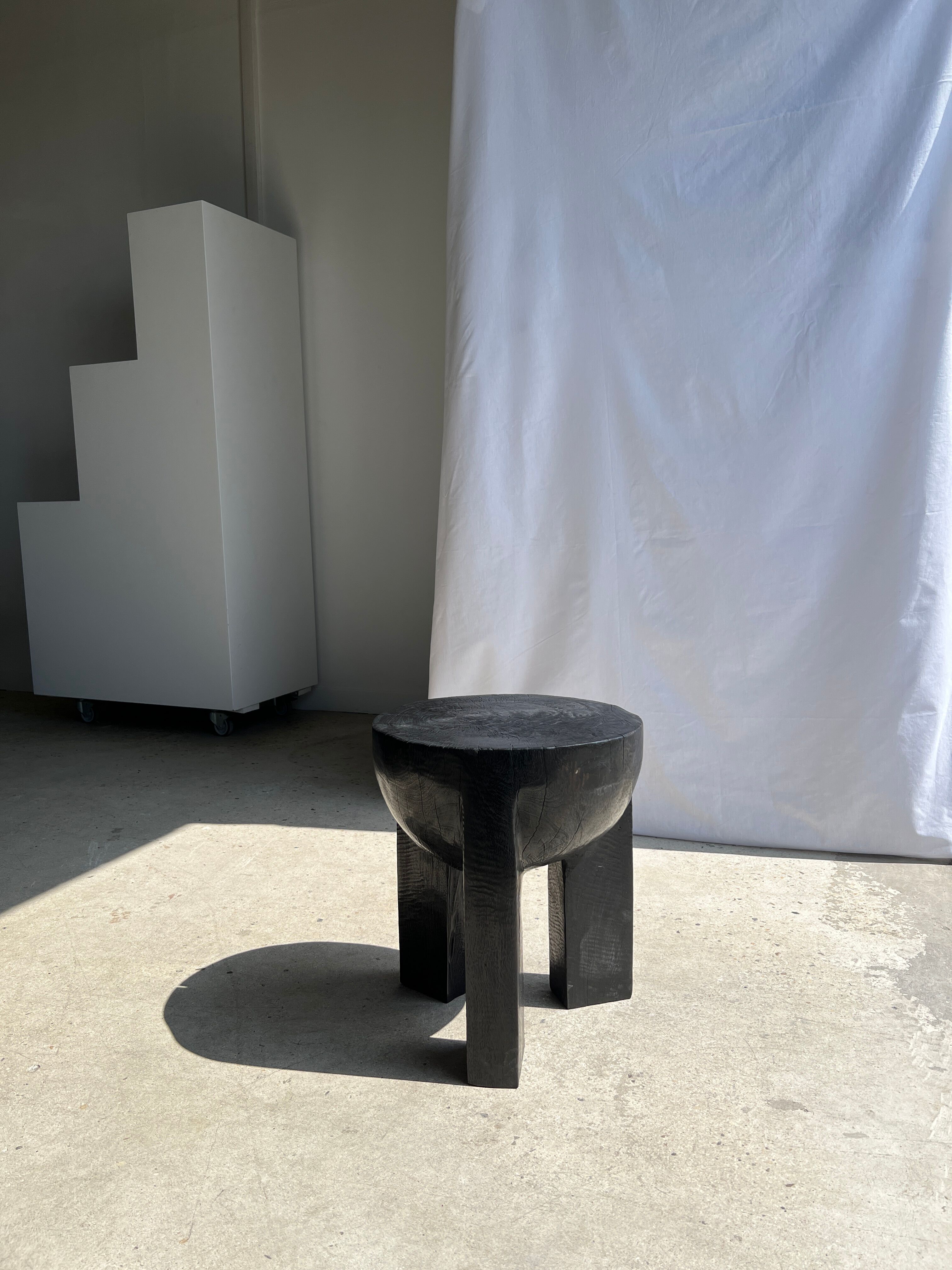 Black mango wood tripod side table with a semi-spherical top, height: 45 cm, diameter: 44 cm.