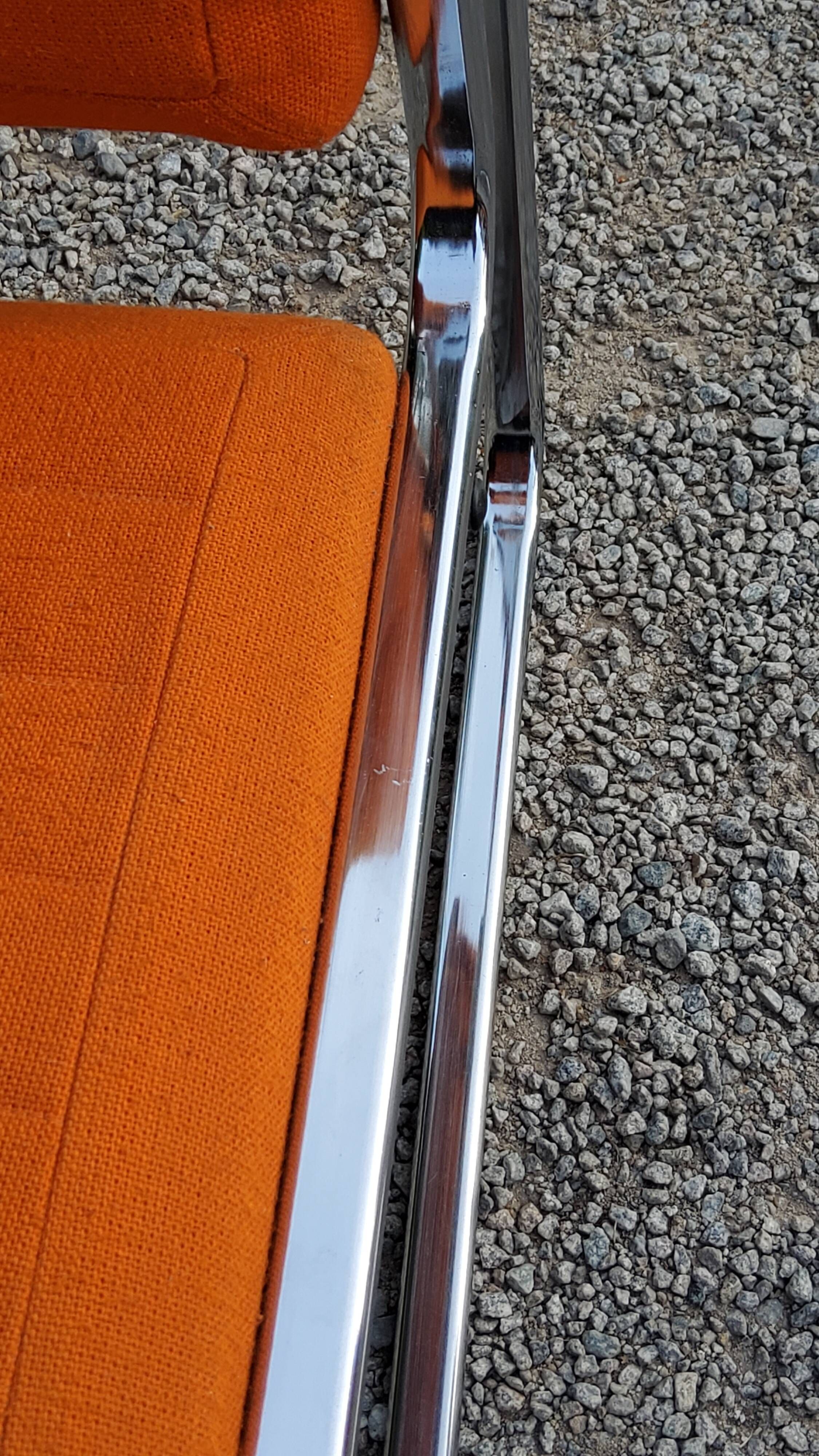 Pair of designer armchairs in orange fabrics and chrome tubes from the 70s