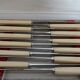 12 vintage stainless steel knives bone or bakelite sleeves in case