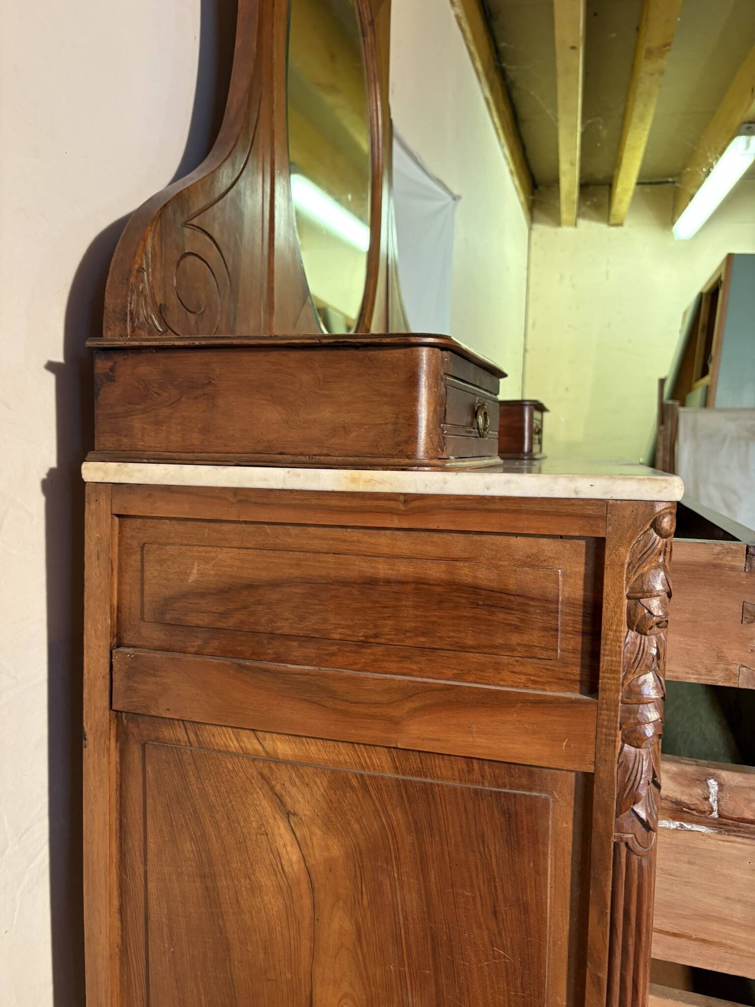 Antique carved wooden dressing table with marble and tilting oval mirror.