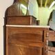 Antique carved wooden dressing table with marble and tilting oval mirror.