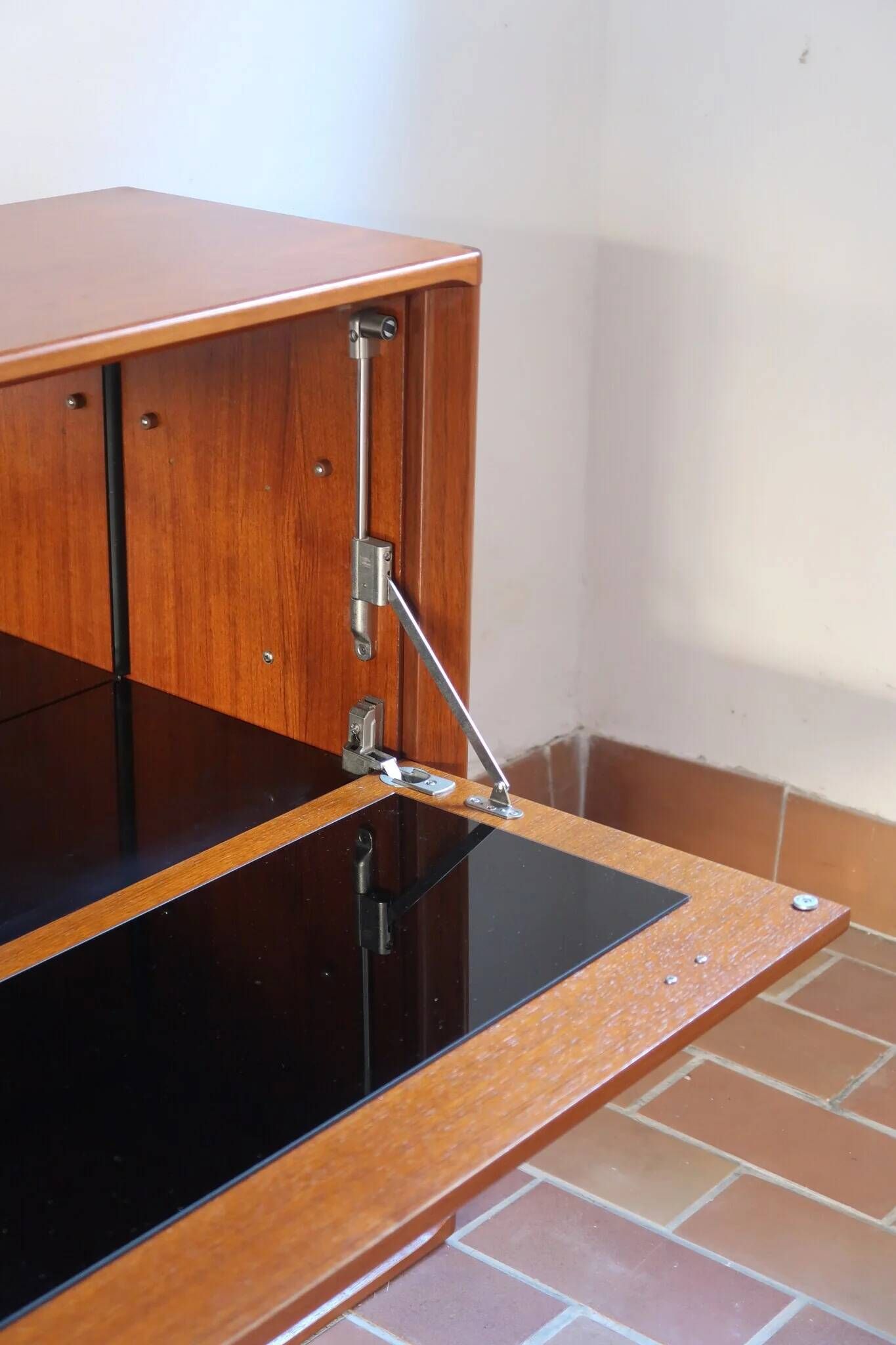 Vintage teak bar cabinet with black glass interior.