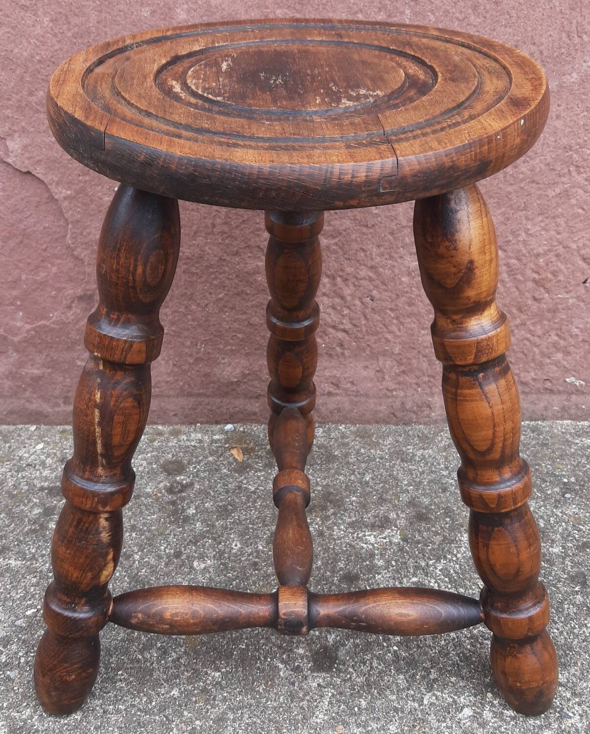 Low wooden tripod stool.